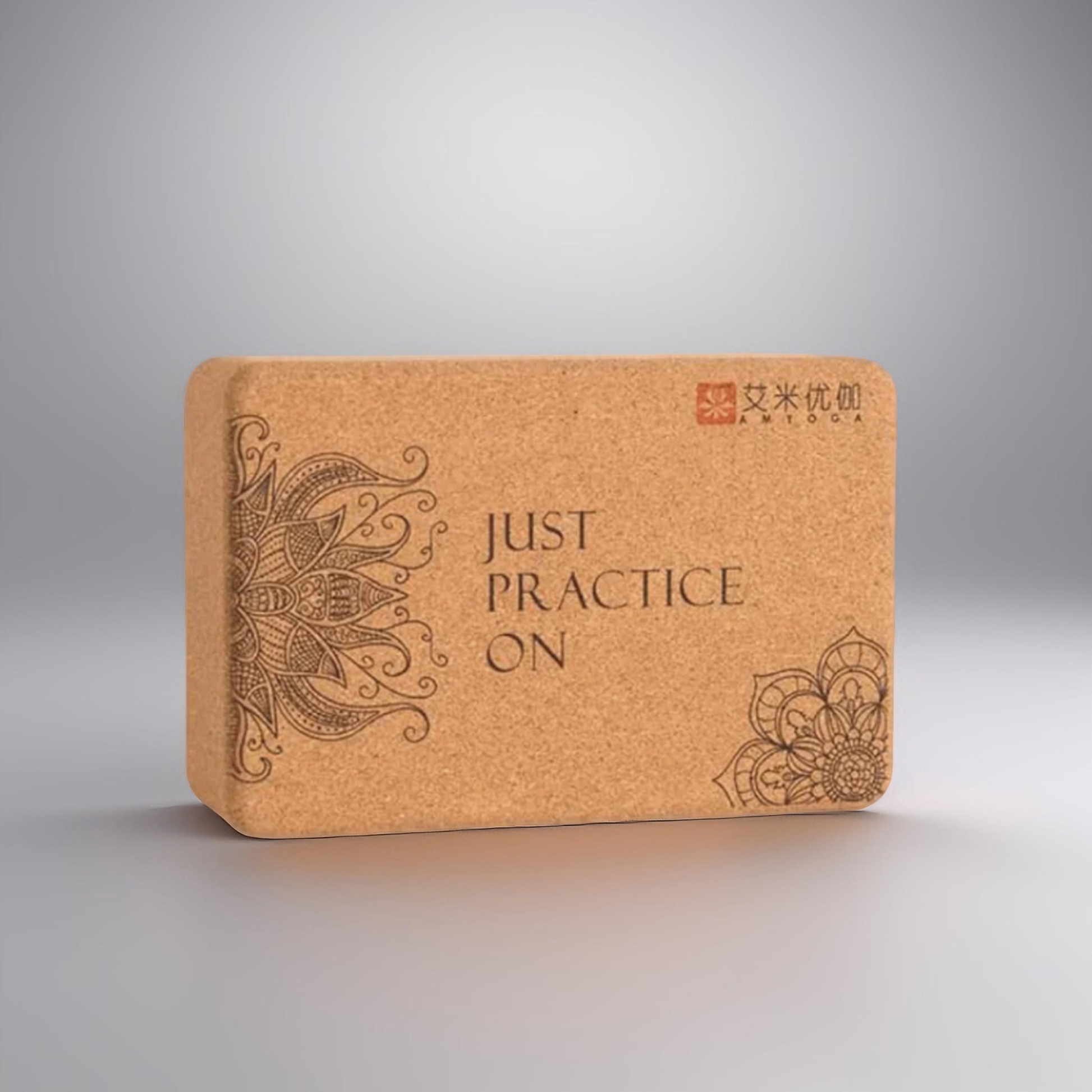 Image of the Core Block, a yoga accessory set featuring two natural cork blocks with intricate designs and the phrase 'Just Practice On.' The blocks, crafted from eco-friendly small-grain cork, are paired with a yoga strap, providing tools for stability, alignment, and flexibility. Ideal for enhancing yoga practice while promoting sustainability.