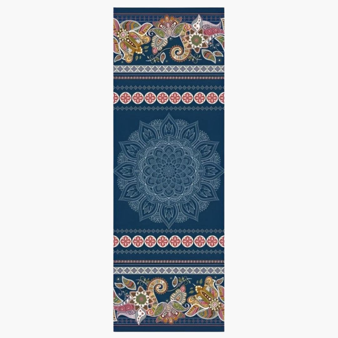 The CornerGrip Yoga Towel in the Midnight Path design is a premium microfiber towel designed to enhance grip, comfort, and hygiene during yoga practice. It features a deep navy blue background with an intricate central mandala, floral patterns, and decorative borders in earthy and vibrant tones, evoking a sense of grounding and spiritual connection. The innovative corner pockets securely anchor the towel to a yoga mat, preventing slipping and bunching for a distraction-free session.