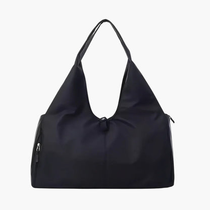 The Move Ease Black Gym and Yoga Bag is a sleek, multifunctional carry-all designed for fitness enthusiasts and travelers. Constructed from durable, water-resistant nylon, this lightweight yet spacious bag comfortably fits a yoga mat, gym clothes, water bottle, and personal essentials.
