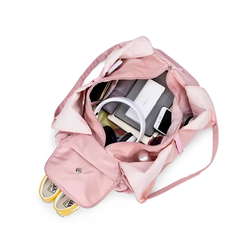 Top-down view of the Move Ease yoga and gym bag in pink, showcasing its spacious interior packed with workout essentials, a yoga ring, shoes, a laptop, and personal items. Designed for organization and convenience, this versatile bag is perfect for active lifestyles.