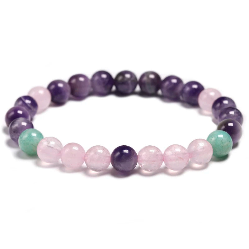 Image of the Mystic Mala, a 108-bead necklace and bracelet made from natural Amethyst, Rose Quartz, and Amazonite stones. It features a vibrant purple tassel and is elegantly displayed on a rustic wooden background, showcasing its spiritual and calming design, ideal for meditation or as a stylish accessory.