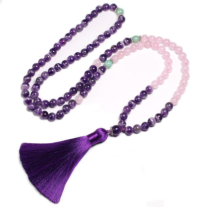 Image of the Mystic Mala, a 108-bead necklace and bracelet made from natural Amethyst, Rose Quartz, and Amazonite stones. It features a vibrant purple tassel and is elegantly displayed on a rustic wooden background, showcasing its spiritual and calming design, ideal for meditation or as a stylish accessory.