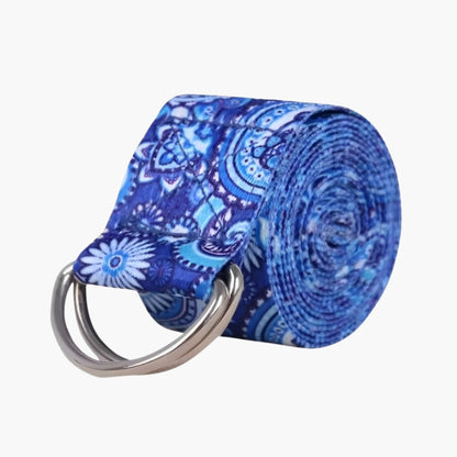 The Plentyoga StretchFlow Yoga Strap in the blue model features an intricate paisley and floral pattern in deep and light blue tones. Made from a durable cotton blend, this strap provides the perfect balance of strength and flexibility to support deep stretches, improve posture, and assist in achieving challenging yoga poses. The sturdy D-ring buckle ensures a secure grip, making the Plentyoga StretchFlow Yoga Strap a versatile and essential tool for yogis of all levels.